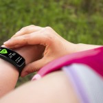 Sporty woman using smart watch. Interface on watch screen was generated in graphical program